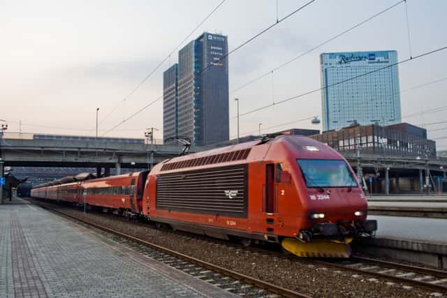 NSB El 18 at Oslo S with Oslo skyline in Oslo, Norway